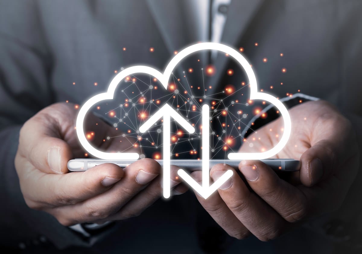 business owner holding cell phone with cloud image - Team Impacts Digital Migration